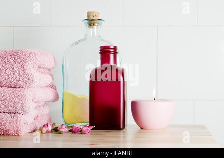 Spa Bad Elemente in pink und gelb Thema auf einer hellen Holzoberfläche gegen einen weißen gefliesten Wand bietet textfreiraum nach oben rechts Stockfoto