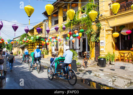 Touristen auf einem Cyclo tour, bunte Laternen in Hoi an, Vietnam Stockfoto