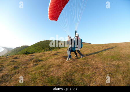 Tandem Gleitschirm über dem Strand ausziehen. Stockfoto