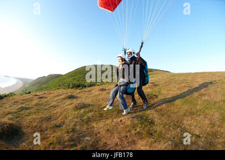 Tandem Gleitschirm über dem Strand ausziehen. Stockfoto