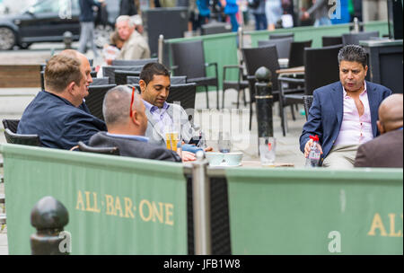 Smart mittlere gealterte Männer in Anzügen, die draußen sitzen in einer Bar in Brighton. Stockfoto