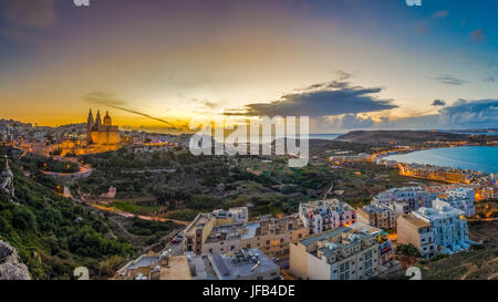 Il-Mellieha, Malta-schöne Panorama Skyline Blick auf Mellieha Stadt bei Sonnenuntergang mit Paris Kirche und Mellieha Strand im Hintergrund mit blauem Himmel und Stockfoto