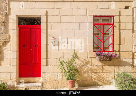 Senglea, Malta - traditionelle rote Tür und Fenster eines alten maltesischen Hauses in Senglea an einem sonnigen Sommertag Stockfoto