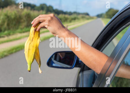 Arm fallen Schalen von Bananen aus dem Auto Fenster Stockfoto