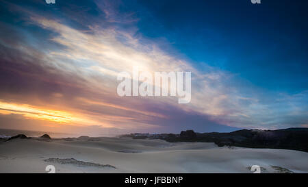 Sonnenuntergang über dem Strand von Cannon Rocks Stockfoto