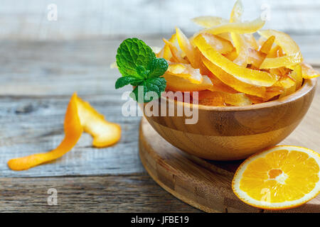 Schüssel mit kandierten Zitrusfrüchten und einem Zweig Minze. Stockfoto