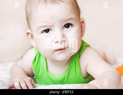 Baby im Bett, starrte mit neugierigen Augen schauen um liegend Stockfoto