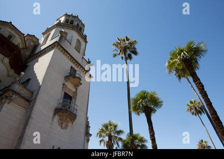 Eine Außenansicht des Hearst Castle und Casa Grande in der Nähe von Palmen. Stockfoto