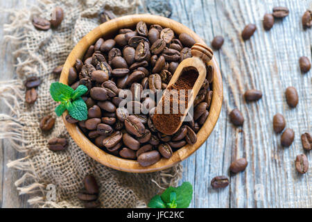 Körner und gemahlenen Kaffee in eine hölzerne Schüssel. Stockfoto