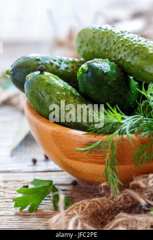 Gesalzene Gurken und Dill in eine hölzerne Schüssel. Stockfoto