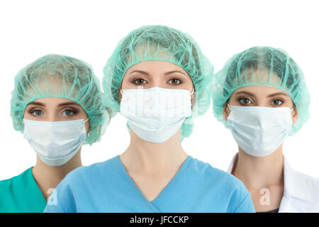 Junge Frau Doktor der Kappe und Gesicht Maske mit zwei ihrer Kollegen stehen hinter ihr. Gesundheitswesen, Medizin, Chirurgie und Team arbeiten-Konzept Stockfoto