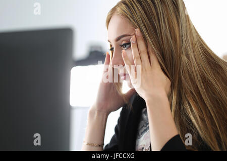 Junge schöne verärgert Business-Frau, die versucht zu konzentrieren, Blick auf Laptop-monitor Stockfoto