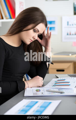 Müde Arbeitnehmerin am Arbeitsplatz im Büro berühren den Kopf versucht, sich zu konzentrieren. Verschlafene Arbeitnehmer in den frühen Morgenstunden. Überforderung, machen Fehler, Stockfoto