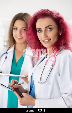 Porträt von zwei Ärztinnen stehend mit Zwischenablage und Tablet bereit zu arbeiten. Gesundheitswesen, medizinische Versorgung oder Bildung und Teamwork Konzept. Stockfoto
