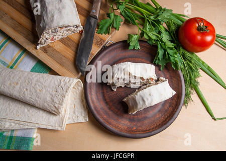 Stücke von dünnen armenische Fladenbrot oder Lavash gewickelt, Tomaten, Käse oder Quark, Hähnchenfleisch, Tomaten und Kräuter - Dill, Zwiebel, Petersilie und bro Stockfoto