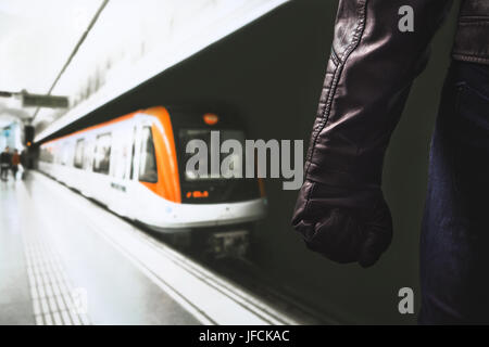 Gewalt in öffentlichen Verkehrsmitteln. Droht gefährlichen Mann in u-Bahn-Plattform stehen. Faust und Arm mit schwarzem Leder-Handschuh. Stockfoto