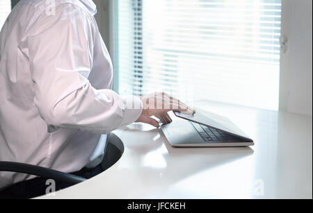 Büroangestellten gestartet oder beendet Arbeitstag durch Öffnen oder Schließen der Laptop-Deckel. Gehen nach der Arbeit nach Hause oder kommen wieder in den Morgen. Business-Mann. Stockfoto