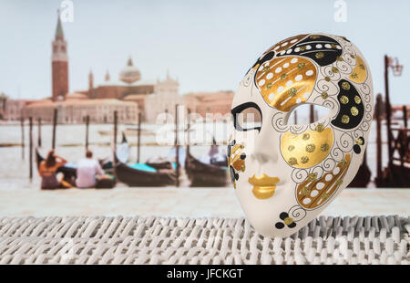 Traditionelle venezianische Maske mit Ankern Gondeln, romantisch zu zweit und Kirche San Giorgio Maggiore im unscharfen Hintergrund. Heißer Sommer-Urlaubs-feeling Stockfoto