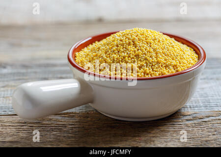 Bio Hirse in eine keramische Schüssel. Stockfoto