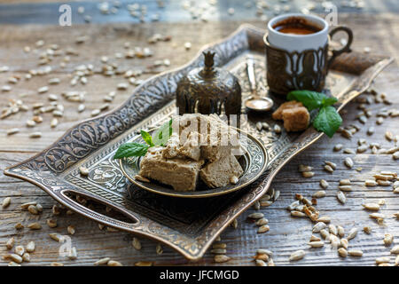 Halva auf einem Tablett und eine Tasse schwarzen Kaffee. Stockfoto