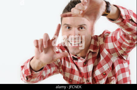 Porträt junger Mann zeigt Finger Frame Blick in die Kamera auf weißem Hintergrund. Menschliche Emotionen Gesichtsausdruck Gefühl Stockfoto