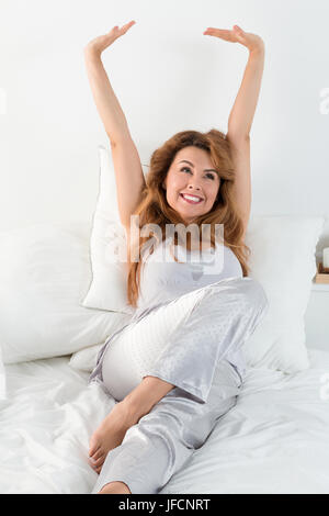 Junge hübsche Frau streckt sich am Morgen in ihrem Bett zu legen. Einfach aufwachen und glücklicher Morgen Stockfoto