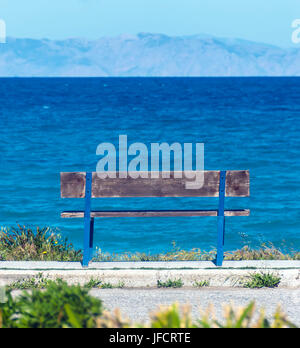 Holzbank mit Blick auf das Meer und die Berge Stockfoto