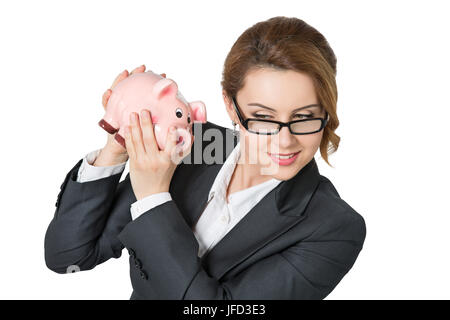 Schönes Lächeln auf den Lippen Geschäftsfrau schütteln Sparschwein Überprüfung Geldbetrag isoliert auf weißem Hintergrund. Banking, Insuarance und Geld Kapital Konzeptionierung Stockfoto