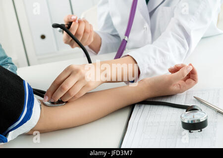 Weibliche Medizin Arzt Blutdruckmessung für Patienten. Gesundheitswesen und medizinische Konzept. Close-up iin Arzt und Patient Hände, während Druck meas Stockfoto