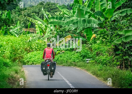 Weibliche Radfahrer Fahrrad durch Tropen in Lombok, Indonesien Stockfoto