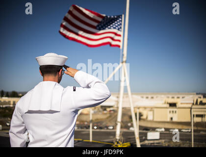 170627-N-LK571-108 SAN DIEGO (27. Juni 2017) Operations Specialist 3. Klasse Benjamin Kirkpatrick, der Flugzeugträger USS Carl Vinson (CVN-70) Color Guard zugewiesen salutiert die nationalen Ensign als es auf Halbmast zu Ehren der sieben Seeleute fliegt an Bord der geführte Flugkörper-Zerstörer USS Fitzgerald (DDG-62) verloren. Carl Vinson ist Expeditionary in seinem Heimathafen San Diego nach Abschluss einer fünf Monaten Einsatz im Westpazifik. (Foto: U.S. Navy Mass Communication Specialist 3. Klasse Matthew Granito/freigegeben) Stockfoto