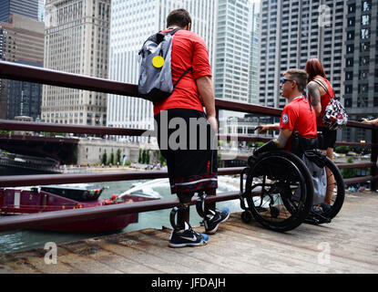 CHICAGO (29. Juni 2017) Krieger Spiele Athleten vom Team Marine Corps beobachten ein Chicago Fire Department Löschboot einen Wasser-Gruß für die Verwundeten Krieger der 2017 Abteilung der Verteidigung Verwundeten Krieger Spiele zu rendern. Die DoD-Krieger-Spiele sind ein jährliches Ereignis, so dass die Verwundeten, Kranken und verletzten Soldat innen und Veteranen im Paralympischen anmutende Sportarten wie Bogenschießen, Radfahren, Feld, schießen, sitzen Volleyball, Schwimmen, konkurrieren zu verfolgen und Rollstuhl-Basketball. (Foto: DoD Mass Communication Specialist 1. Klasse Patrick Gordon/freigegeben) Stockfoto