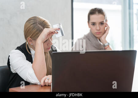 Zwei besorgt Frau Probleme Onlinekauf mit Kreditkarte und Laptop im Wohnzimmer in ein Haus innen sitzen. Stockfoto