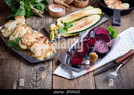 In Scheiben geschnittene rote Beete, Zucchini und Blumenkohl Steaks auf rustikale Party im freien Tisch.  Vielzahl von gebratenem Gemüse, Diät und gesunde Ernährung Food-Konzept Stockfoto