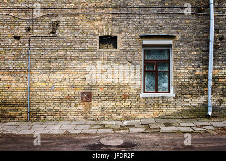 Im Alter von verwitterten Straße Wand mit einem Fenster. Architektur Detail Hintergrund. Alte gelbe Mauer Stockfoto