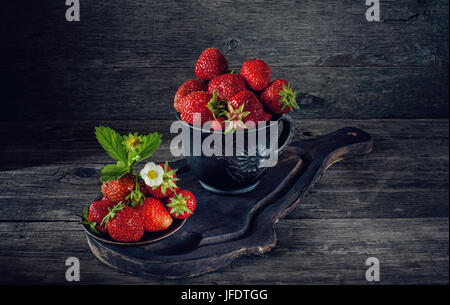 Reife frische Erdbeeren in einem Tontopf im rustikalen Stil. Kunst. Die horizontalen Rahmen. Stockfoto