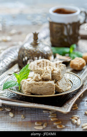 Halva Sonnenblumenkerne und Minze auf einer Bronzetafel. Stockfoto