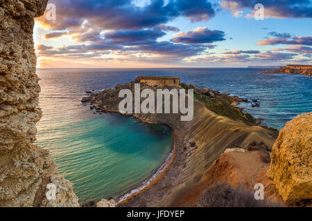 Mgarr, Malta - Panorama von Gnejna und Ghajn Tuffieha Bay, der zwei schönsten Strände auf Malta bei Sonnenuntergang mit schönen bunten Himmel und goldenen Felsen Stockfoto