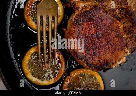 Schweinekotelett auf eisernen Pfanne angebraten Stockfoto