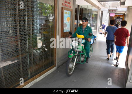 Ein Taiwan Mail Mann mit dem Motorrad um die Nachrichtenübermittlung in Taipei, fahren die meisten Motorräder, wegen seiner Bequemlichkeit zu liefern. Stockfoto