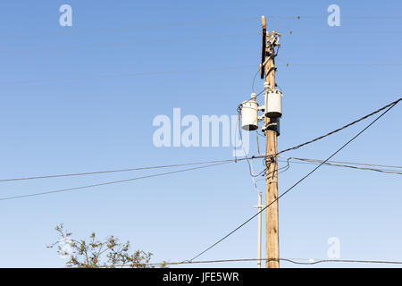 Strom- und Utility Pole und Stromleitungen in den blauen Himmel. Stockfoto