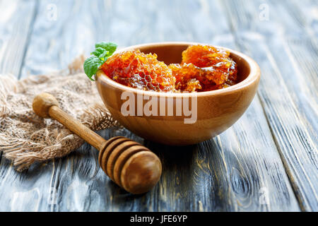 Hölzerne Schüssel mit Honig in den Kamm. Stockfoto