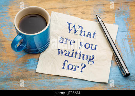 Was wartest du Frage - Handschrift auf einer Serviette mit einer Tasse Espresso-Kaffee Stockfoto