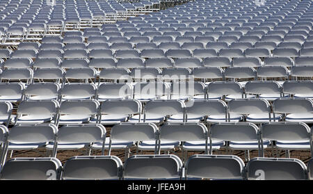 Lose weiße Stühle im Stadion Stockfoto