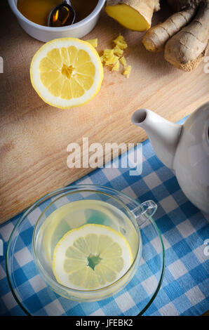 Vertikale Küche Zubereitung Szene mit Zutaten für einen Honig, Zitrone und Ingwer Drink - pflanzliche Hausmittel für die Erkältung und Grippe-Saison. Stockfoto