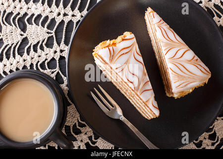 Stücke von Estherhazy Kuchen und Kaffee mit Milch Nahaufnahme auf dem Tisch. horizontale Ansicht von oben Stockfoto