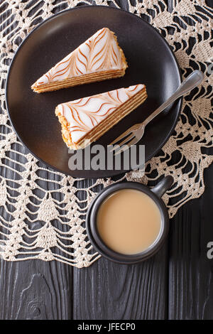 Die Torte von Esterhazy und Kaffee mit Milch Nahaufnahme auf dem Tisch. Vertikale Ansicht von oben Stockfoto