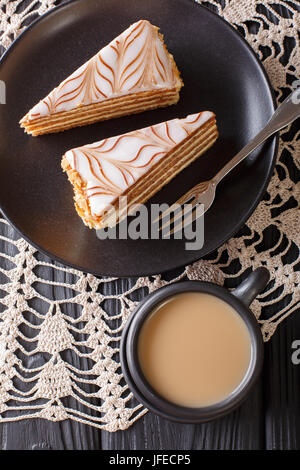 Stücke von Estherhazy Kuchen und Kaffee mit Milch Nahaufnahme auf dem Tisch. Vertikale Ansicht von oben Stockfoto