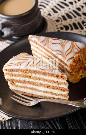 Stück hausgemachten Esterhazy-Torte (Kuchen) mit einer Platte und Kaffee Großaufnahme auf dem Tisch. Vertikal Stockfoto