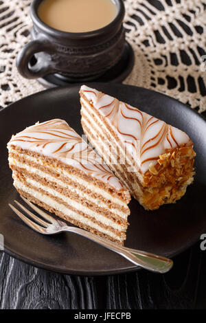 Die Torte von Esterhazy und Kaffee mit Milch Nahaufnahme auf dem Tisch. Vertikal Stockfoto